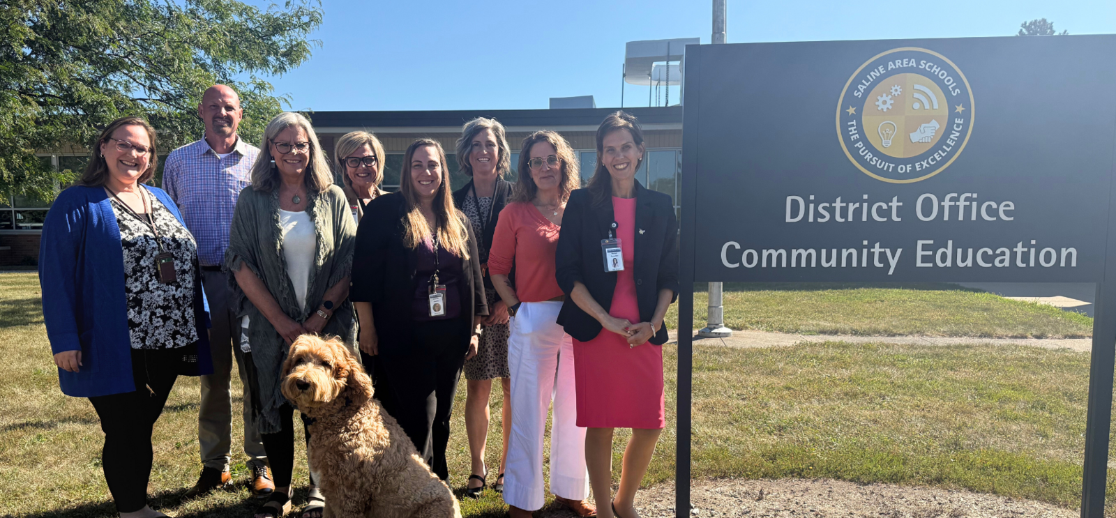 Core posing at the District Office Sign