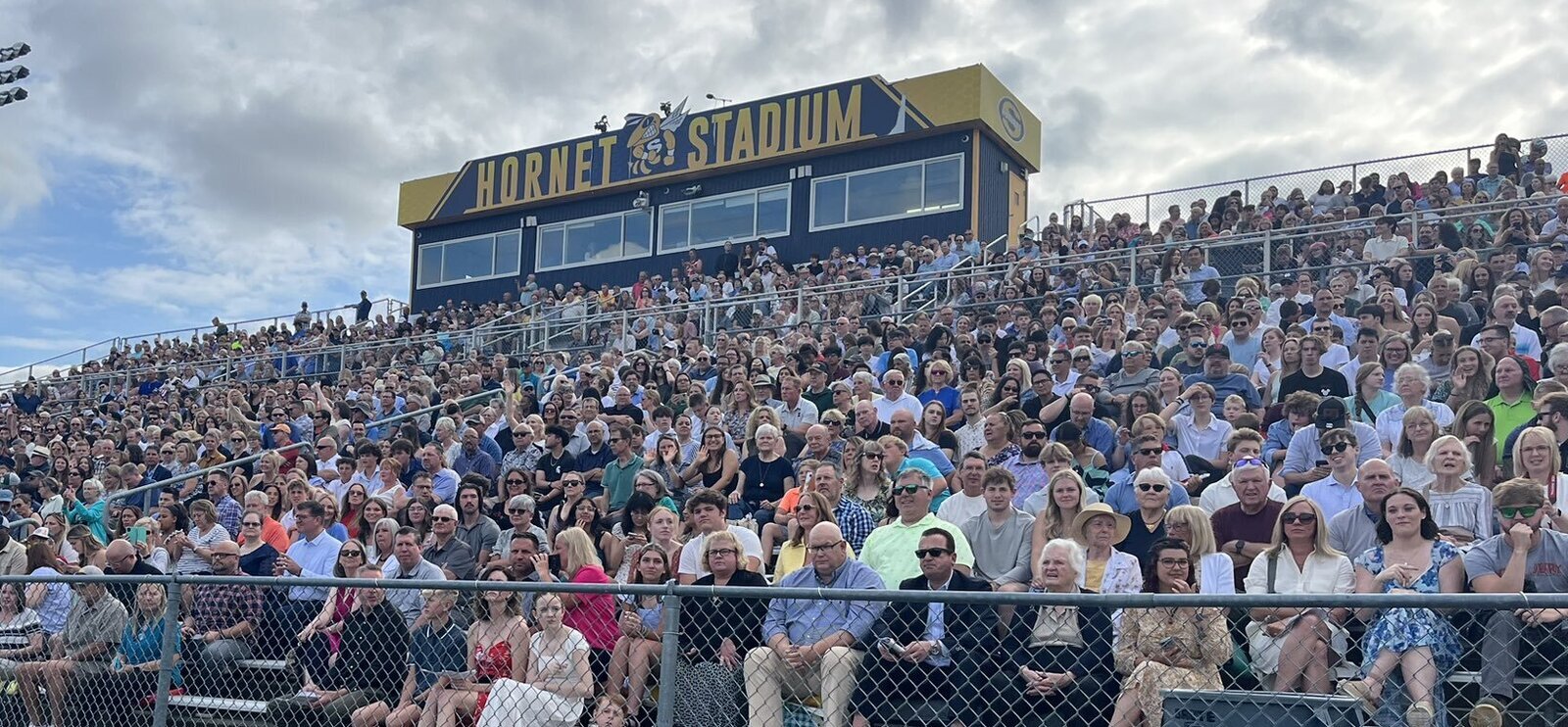 Family and friends watching seniors graduate at Hornet Stadium