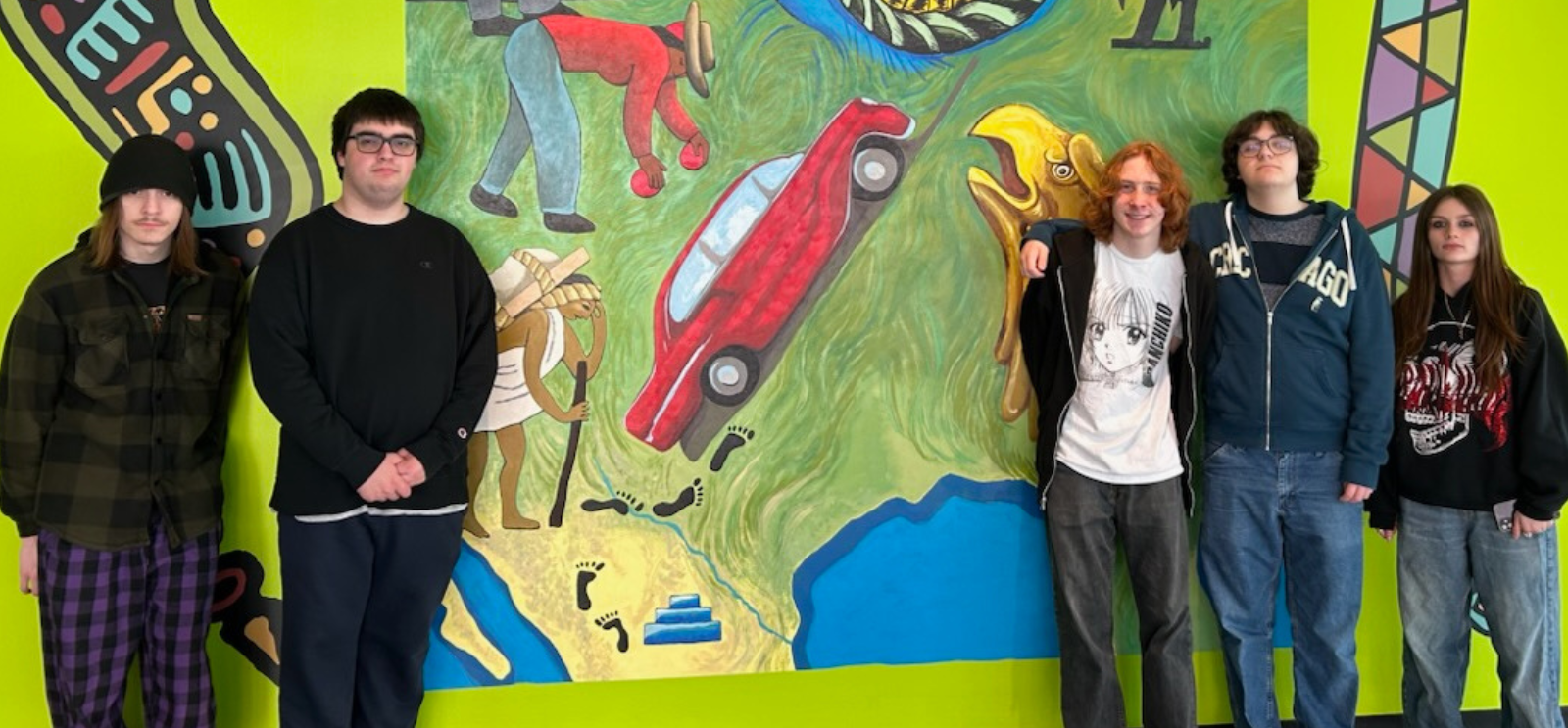 Students standing by a mural on a field trip